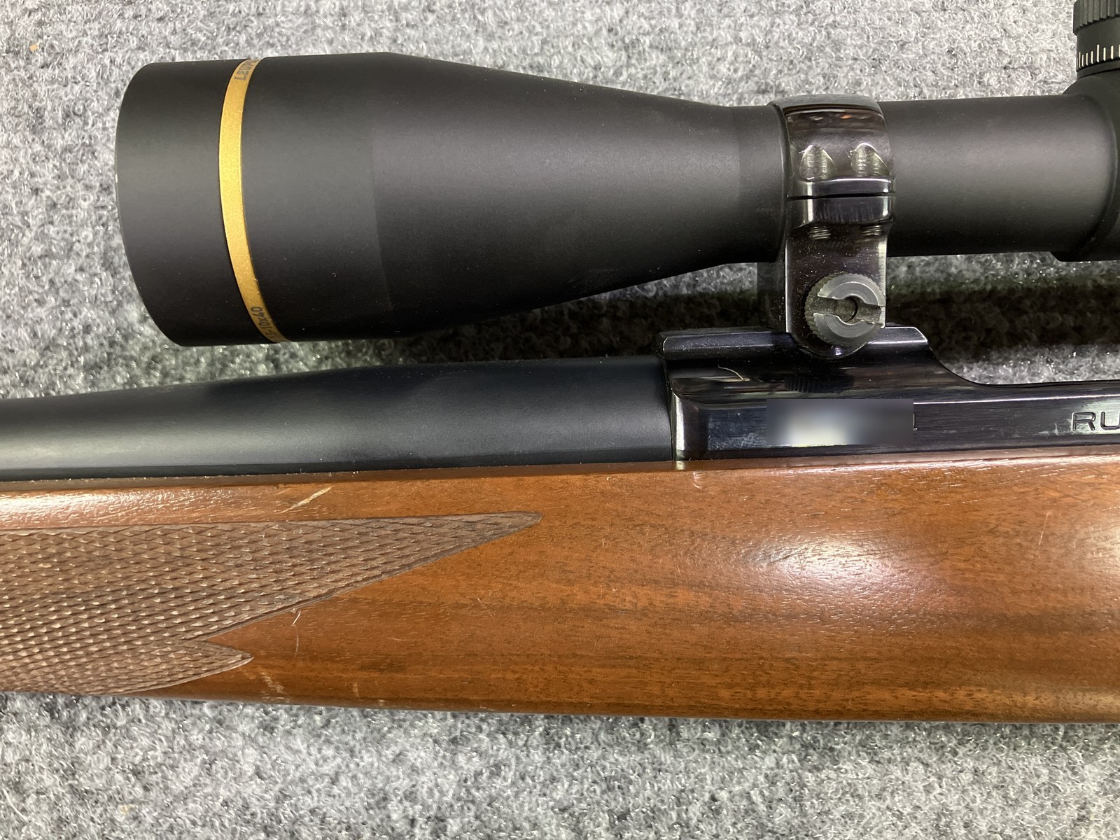 Ruger M77 with stainless barrel Cerakoted Midnight Blue beside a factory blued receiver and blue scope rings