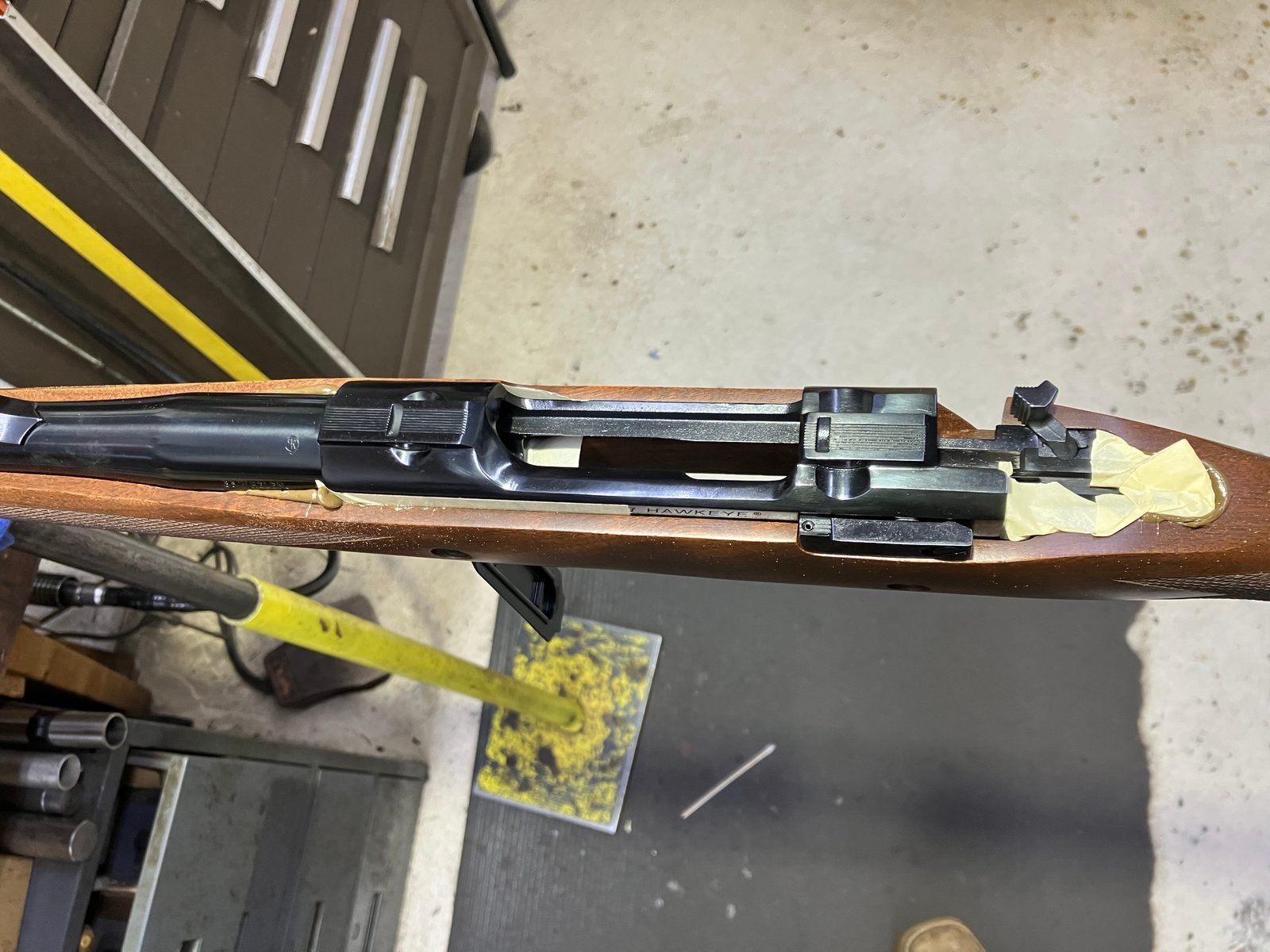 Masked receiver pressed into the stock while excess bedding compound is cleaned from the edges
