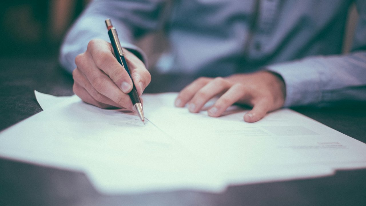 Pen and paperwork on a desk for firearm transfer documents