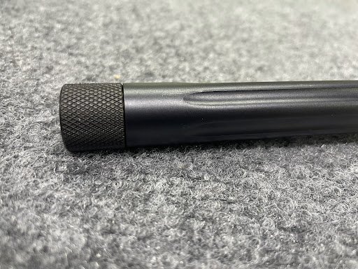 Fluted rifle barrel with a knurled thread protector on the muzzle