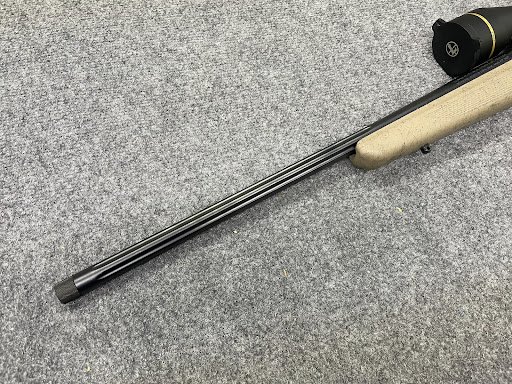 Knurled thread protector installed on a fluted rifle muzzle