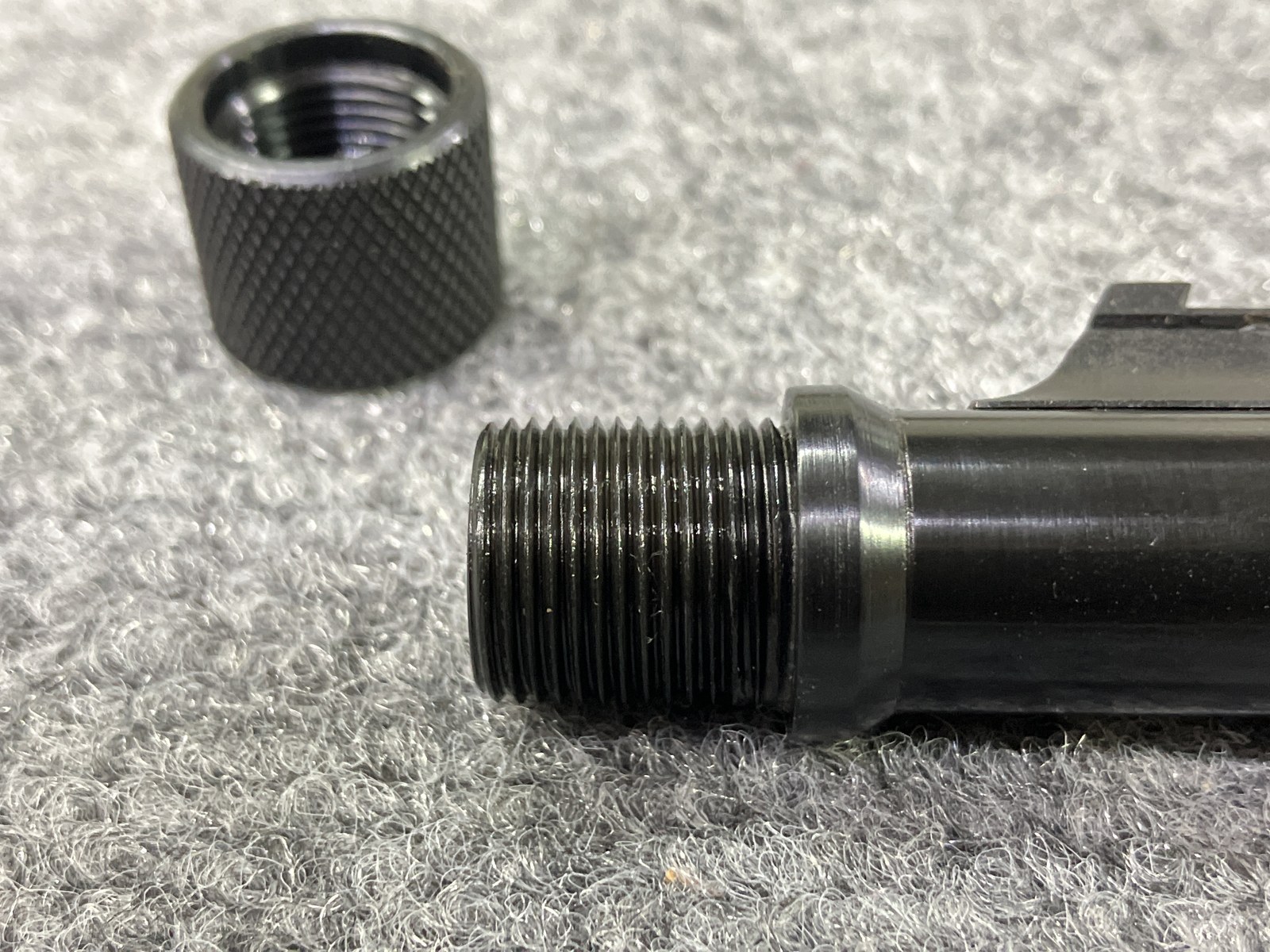 Blued muzzle with suppressor threads and a chrome-moly threaded collar forming an expanded shoulder