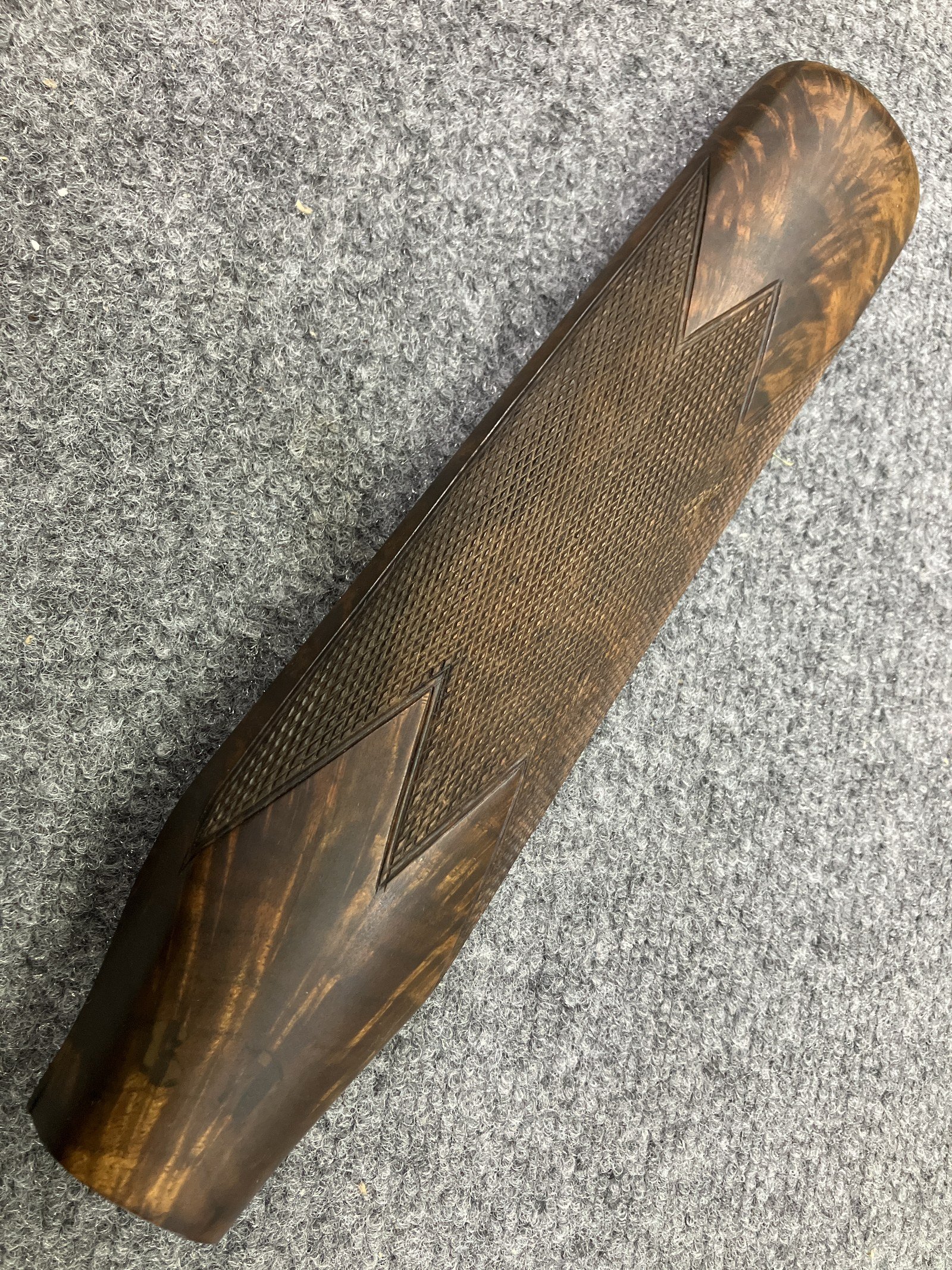 Matte finish on the pistol grip of a checkered walnut rifle stock